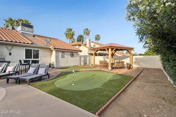 a view of a patio with couches table and chairs under an umbrella