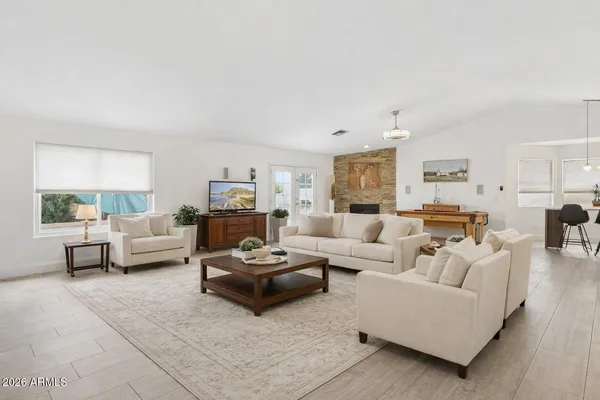 a dining room with furniture a chandelier and wooden floor