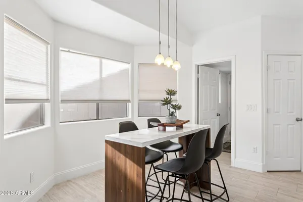 a view of a dining room and livingroom with furniture a rug a fireplace and a chandelier