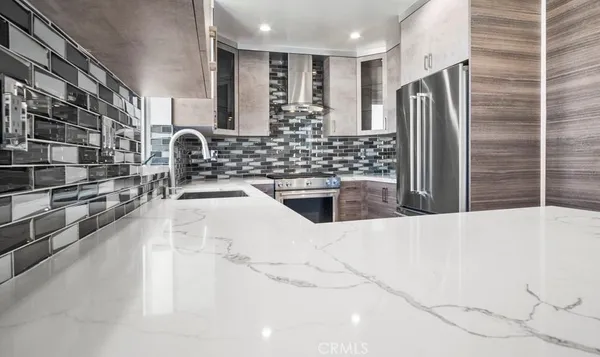 a kitchen with stainless steel appliances a refrigerator and a sink