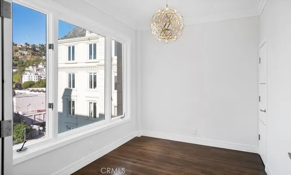 a view of a livingroom with wooden floor and a large window