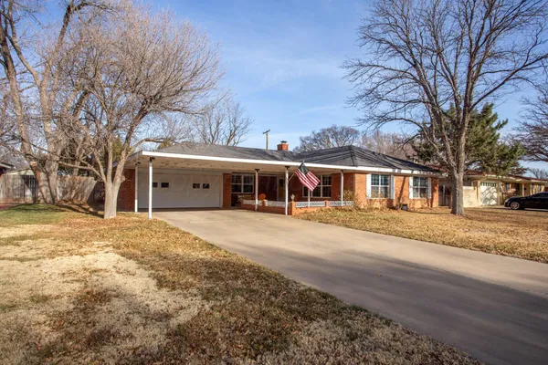 a front view of a house with a yard covered with snow