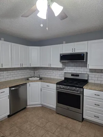 a kitchen with cabinets appliances and a sink
