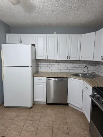 a kitchen with cabinets and white stainless steel appliances