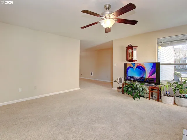 an empty room with windows and a chandelier fan