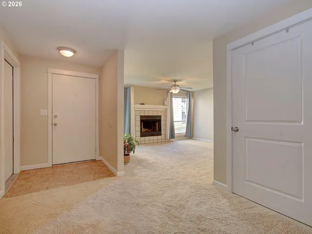 a view of a hallway with an empty room and a fireplace
