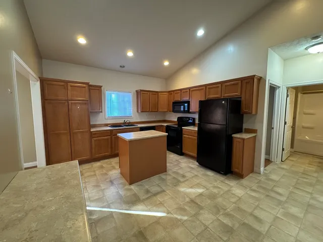 a kitchen with stainless steel appliances granite countertop a refrigerator stove top oven and a sink