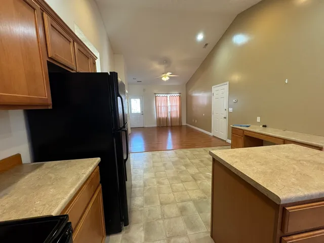 a kitchen with a kitchen island a stove a refrigerator and a sink