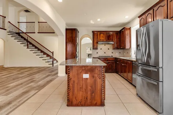 a kitchen with stainless steel appliances granite countertop a refrigerator and a stove top oven