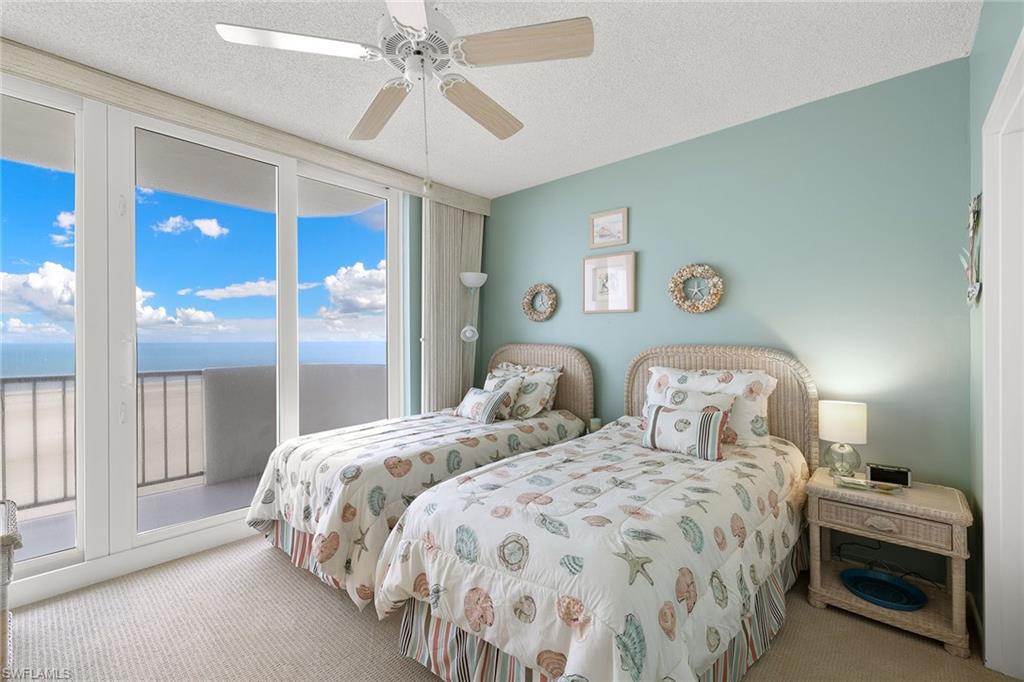 140 Seaview Court, Unit S902 Marco Island, FL 34145 - Photo 14 of 24 a bedroom with two beds and a chandelier