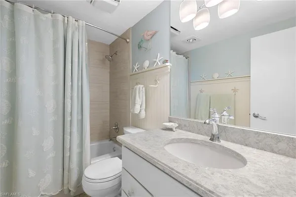 a bathroom with a granite countertop sink a toilet and a mirror