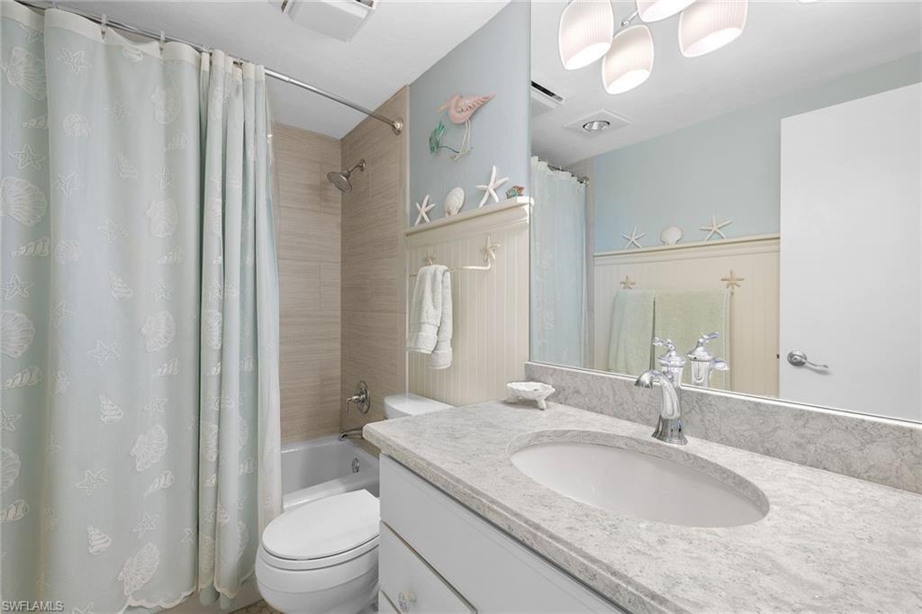 140 Seaview Court, Unit S902 Marco Island, FL 34145 - Photo 16 of 24 a bathroom with a granite countertop sink a toilet and a mirror