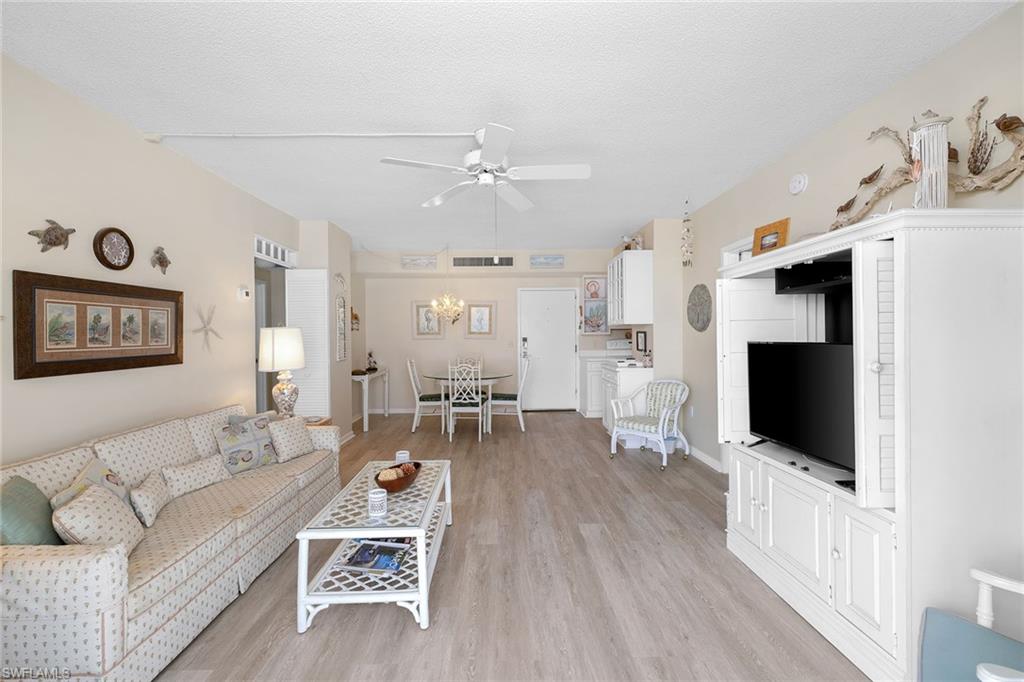 140 Seaview Court, Unit S902 Marco Island, FL 34145 - Photo 5 of 24 a living room with furniture a flat screen tv and kitchen view