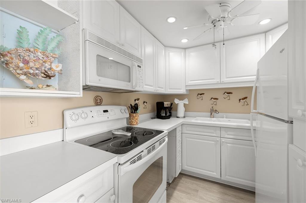 140 Seaview Court, Unit S902 Marco Island, FL 34145 - Photo 7 of 24 a kitchen with cabinets appliances a sink and a window