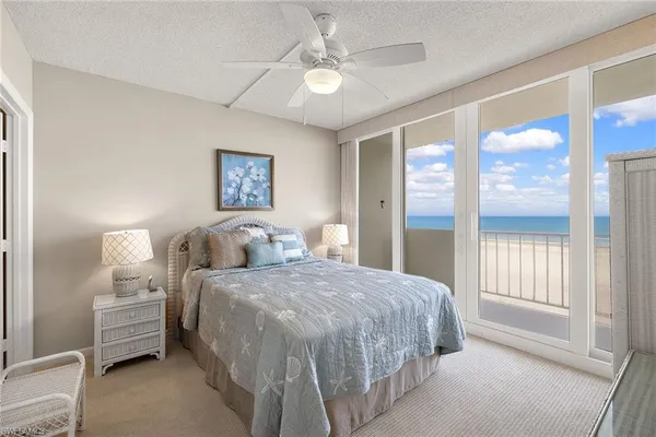 a bedroom with a bed and a large window with a chandelier
