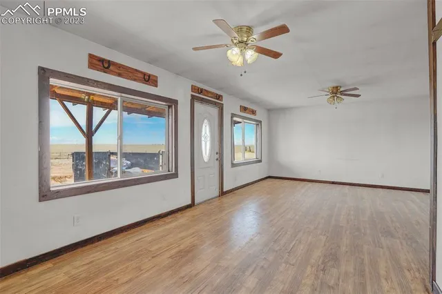 a view of an empty room with a window and wooden floor