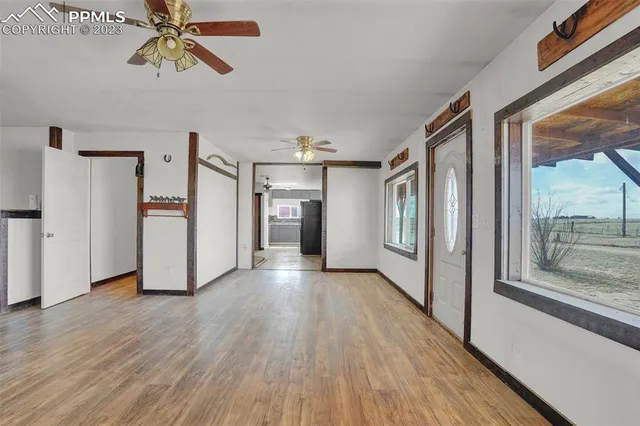a view of a hallway with wooden floor and windows