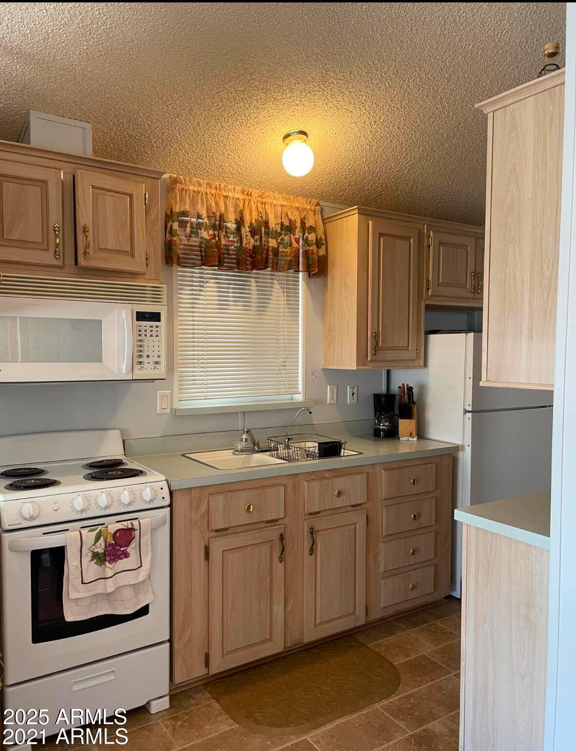 1196 West Klamath Circle, Unit 196 Apache Junction, AZ 85119 - Photo 5 of 8 a kitchen with a stove a sink and a microwave