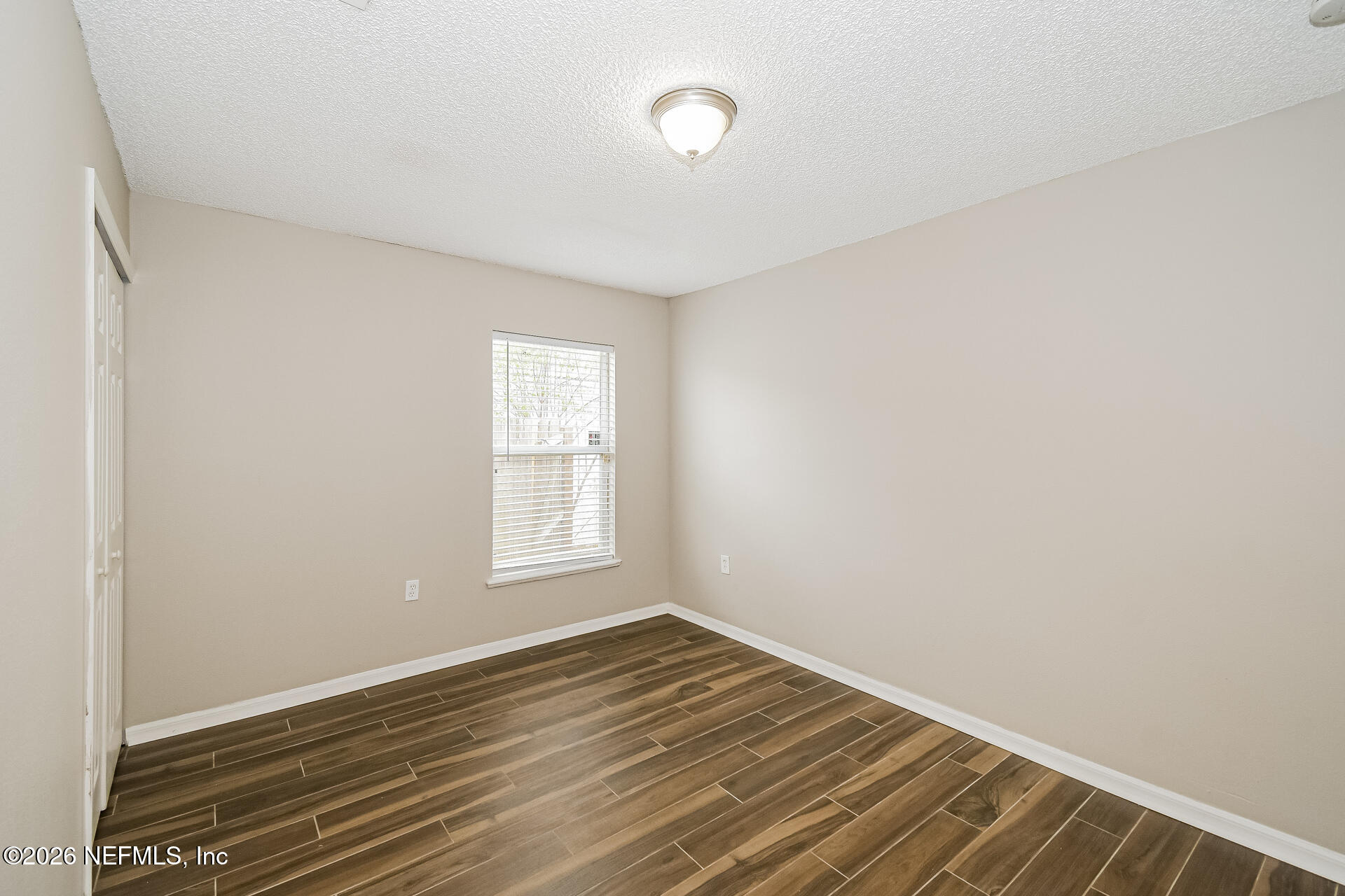 7319 Wood Duck Road Jacksonville, FL 32244 - Photo 17 of 21 an empty room with wooden floor and windows