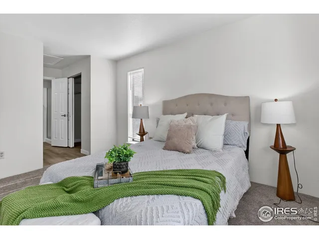 a bedroom with a bed potted plant and a lamp on table