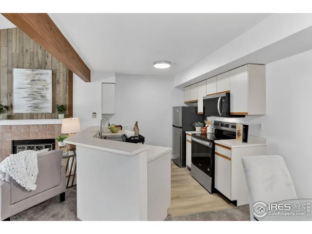 a kitchen with stainless steel appliances kitchen island granite countertop a stove top oven a sink a dining table and chairs