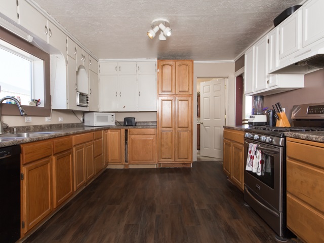 1102 21 Road Grand Junction, CO 81505 - Photo 2 of 20 a kitchen with granite countertop a refrigerator a sink dishwasher and white cabinets with wooden floor
