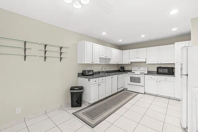 a kitchen with white cabinets a sink and white appliances