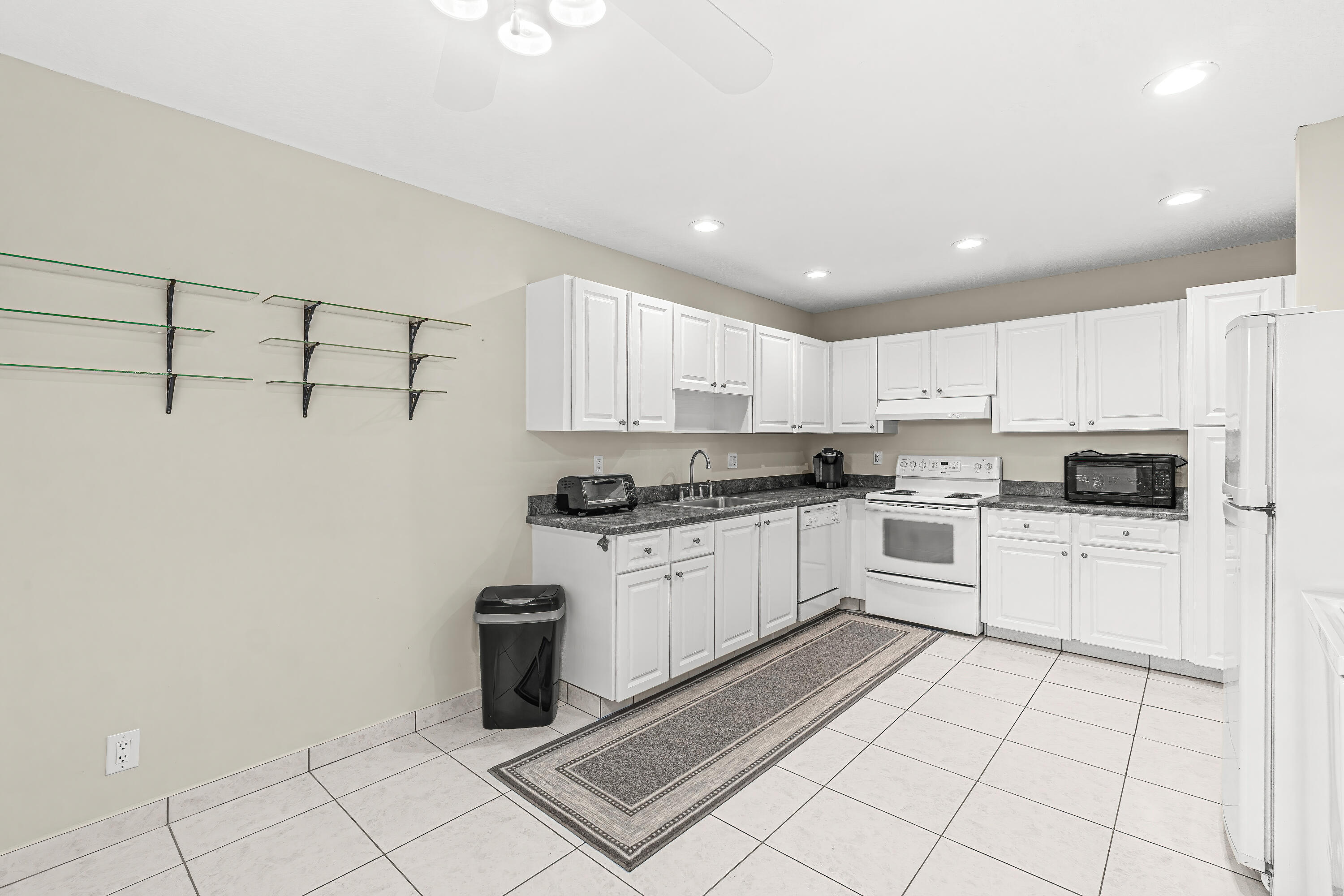 1521 Northwest 19th Terrace, Unit 202 Delray Beach, FL 33445 - Photo 11 of 32 a kitchen with white cabinets a sink and white appliances