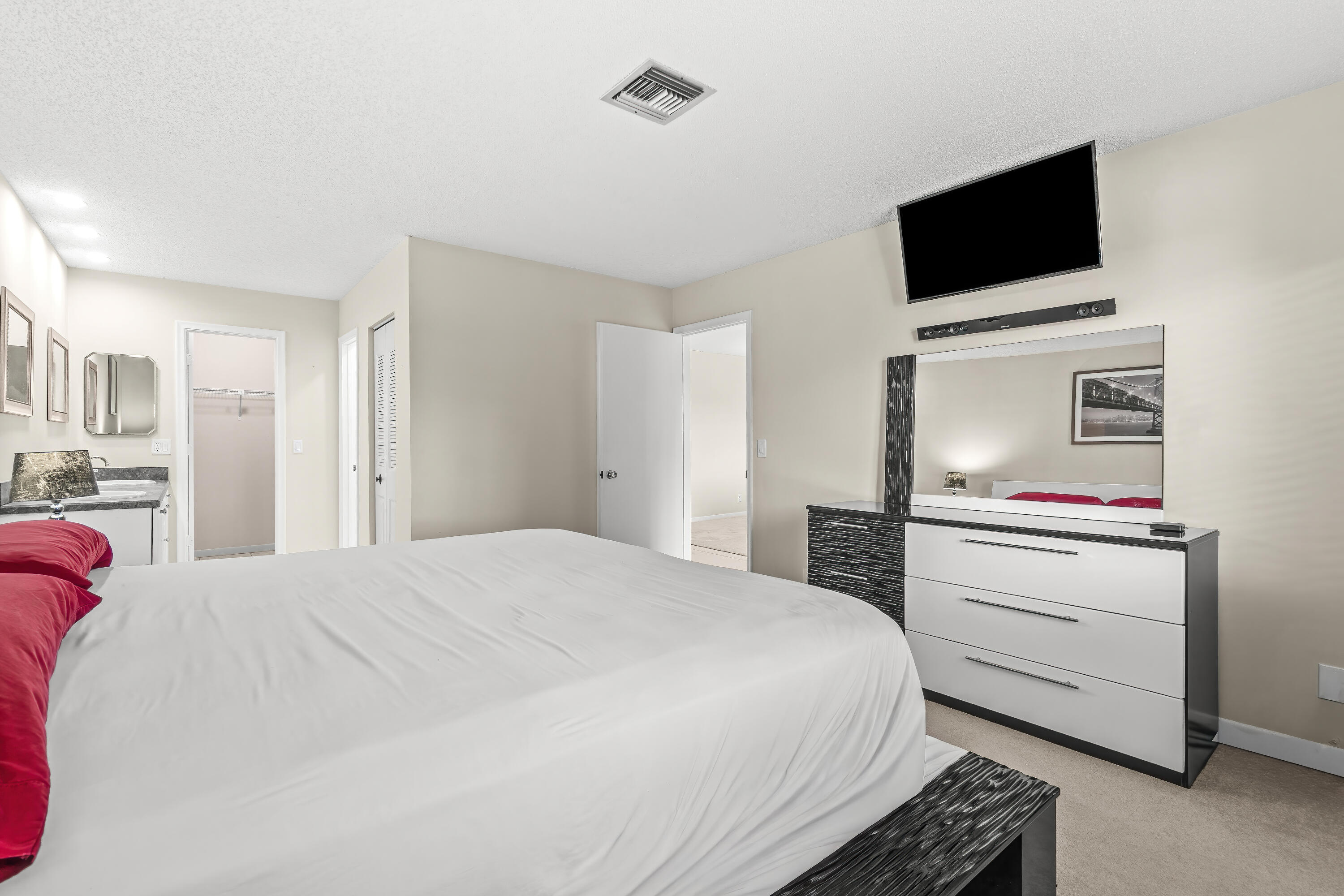 1521 Northwest 19th Terrace, Unit 202 Delray Beach, FL 33445 - Photo 19 of 32 a bedroom with a bed and a flat screen tv