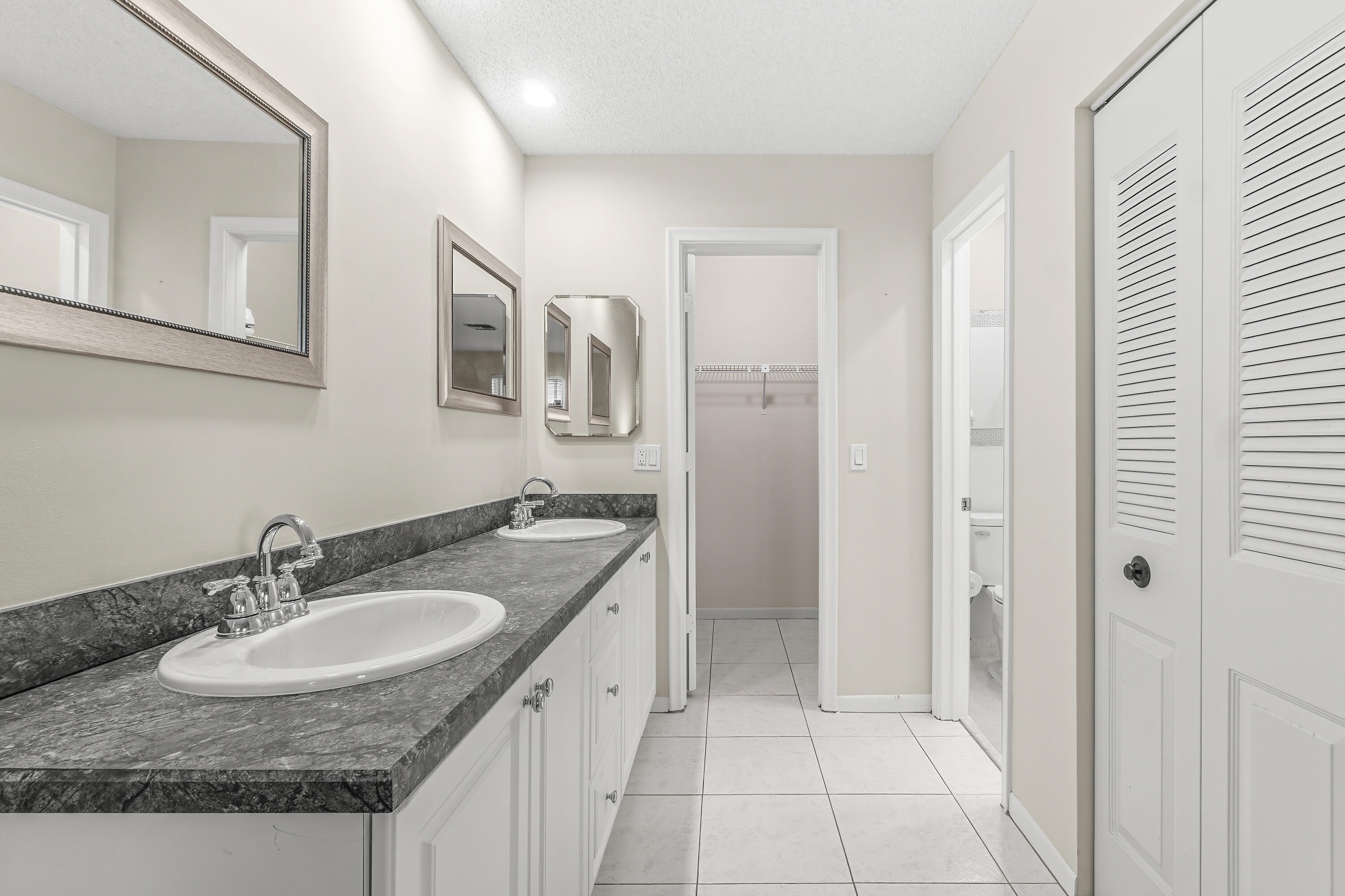 1521 Northwest 19th Terrace, Unit 202 Delray Beach, FL 33445 - Photo 21 of 32 a bathroom with a granite countertop sink and a mirror