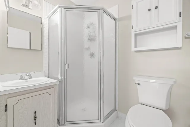 a bathroom with a toilet a sink a vanity and mirror