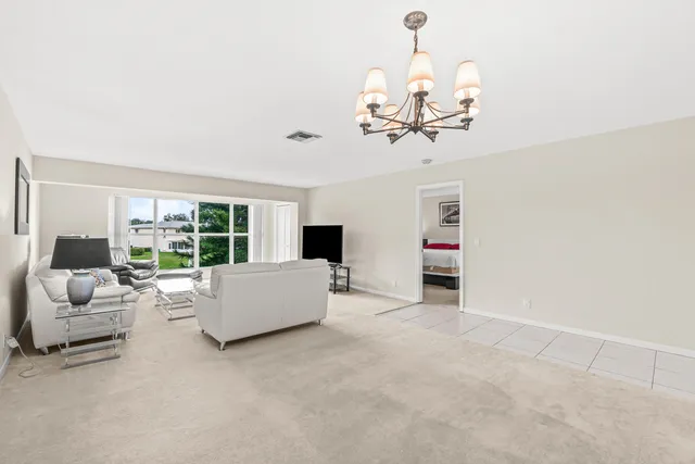 a living room with furniture chandelier and a flat screen tv