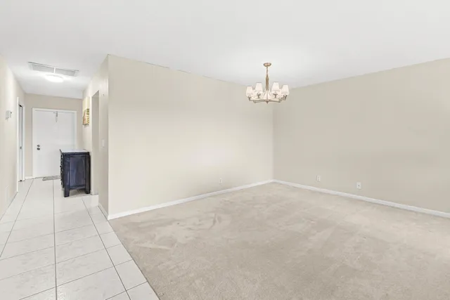 en empty room with chandelier and fireplace