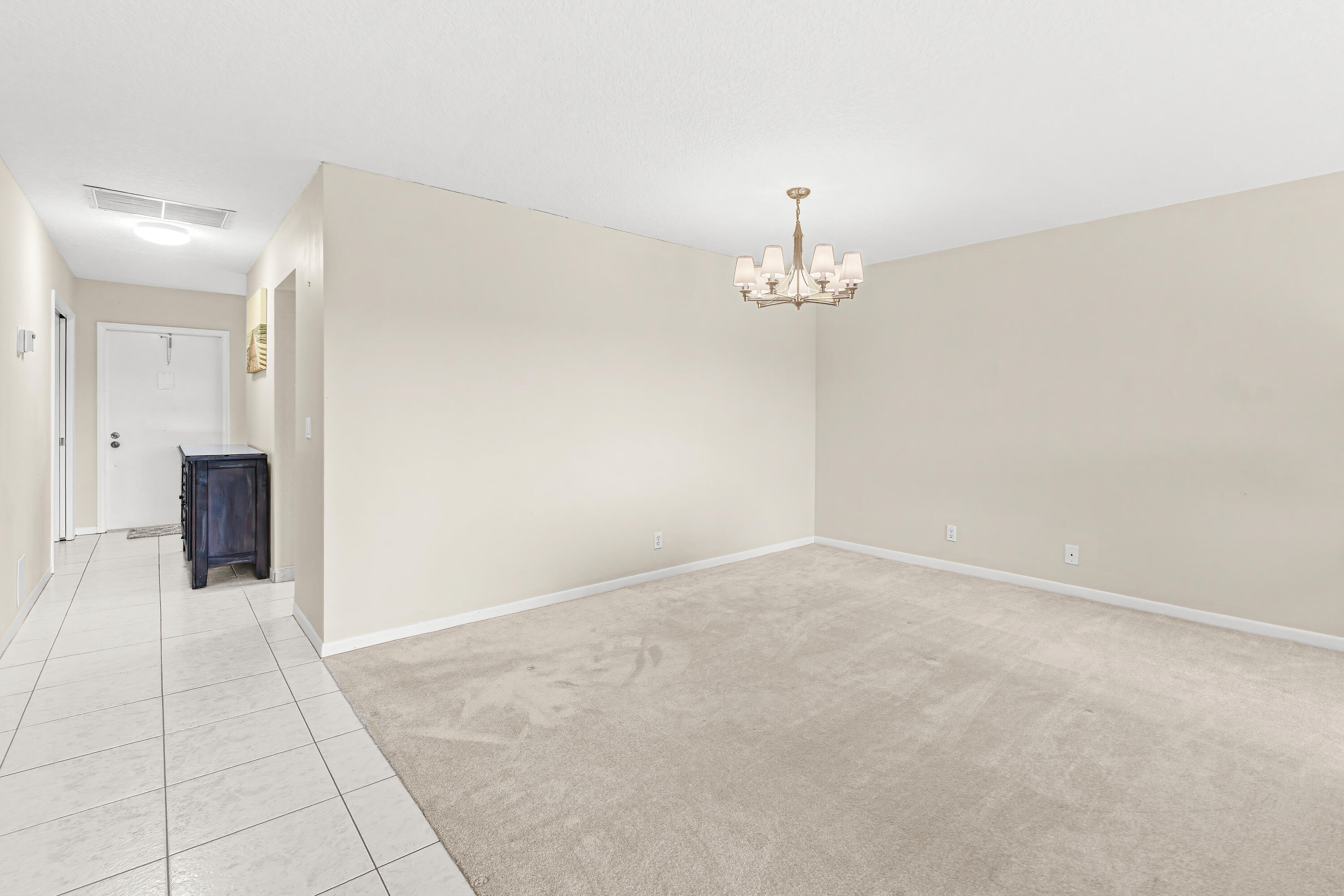 1521 Northwest 19th Terrace, Unit 202 Delray Beach, FL 33445 - Photo 10 of 32 en empty room with chandelier and fireplace