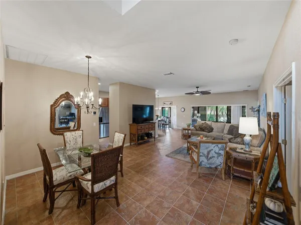 a living room with furniture kitchen view and a chandelier