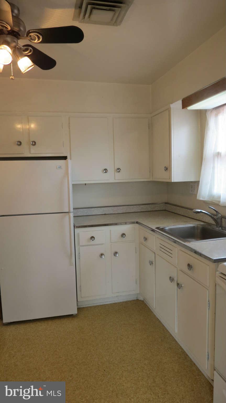 2401 Cameron Mills Road Alexandria, VA 22302 - Photo 14 of 30 a kitchen with granite countertop white cabinets and white appliances