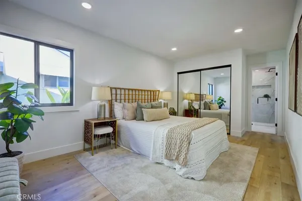 a bedroom with a bed a mirror and furniture