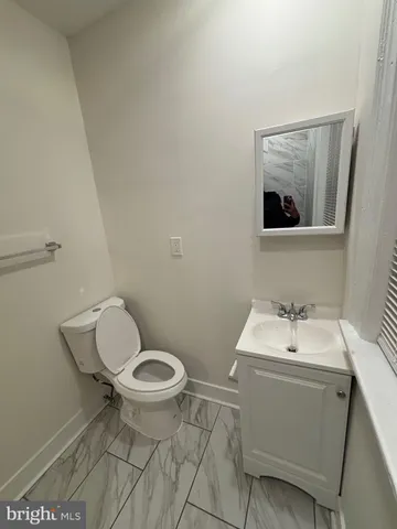 a bathroom with a toilet a sink and mirror