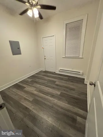 en empty room with wooden floor and fan