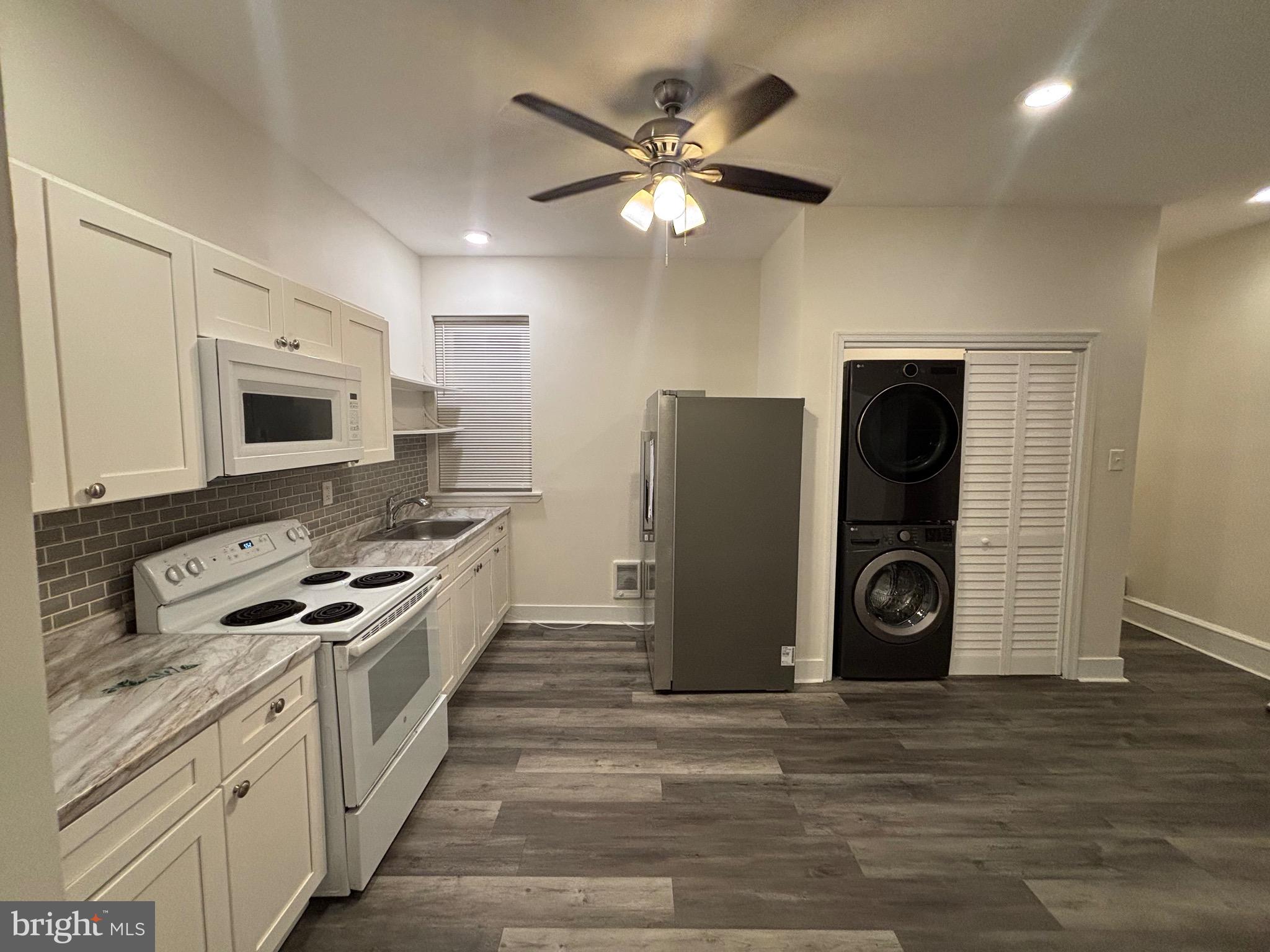 5427 Walnut Street, Unit F1 Philadelphia, PA 19139 - Photo 6 of 22 a kitchen with stainless steel appliances granite countertop a stove a refrigerator and a microwave