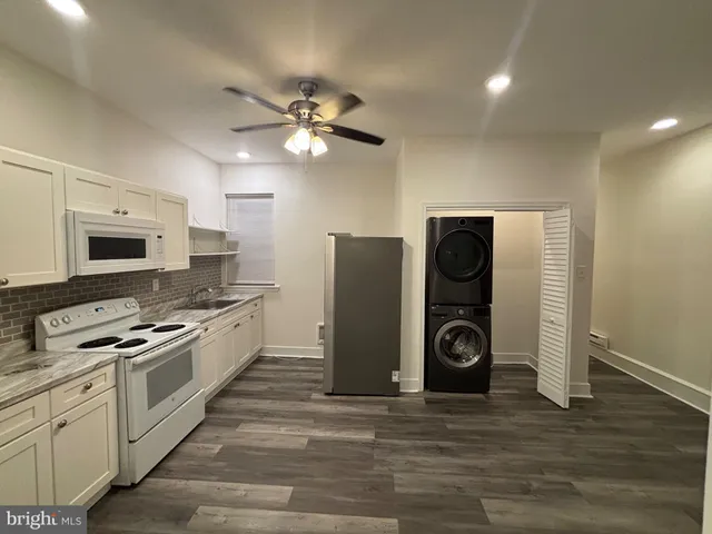 a kitchen with stainless steel appliances granite countertop a refrigerator a stove and a sink