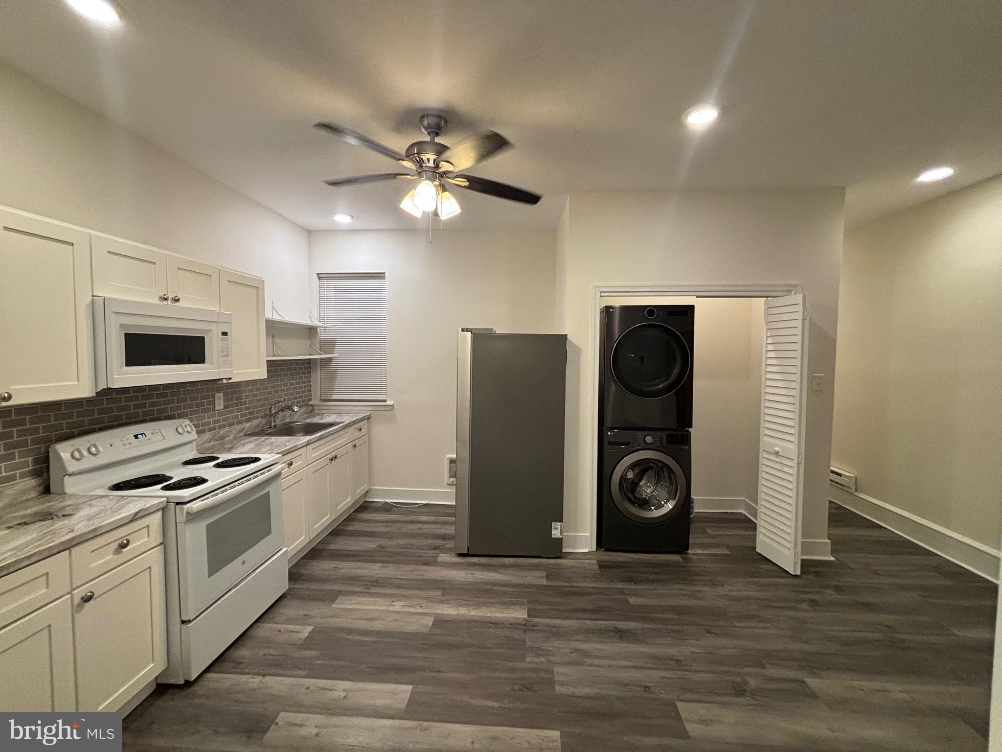 5427 Walnut Street, Unit F1 Philadelphia, PA 19139 - Photo 7 of 22 a kitchen with stainless steel appliances granite countertop a refrigerator a stove and a sink