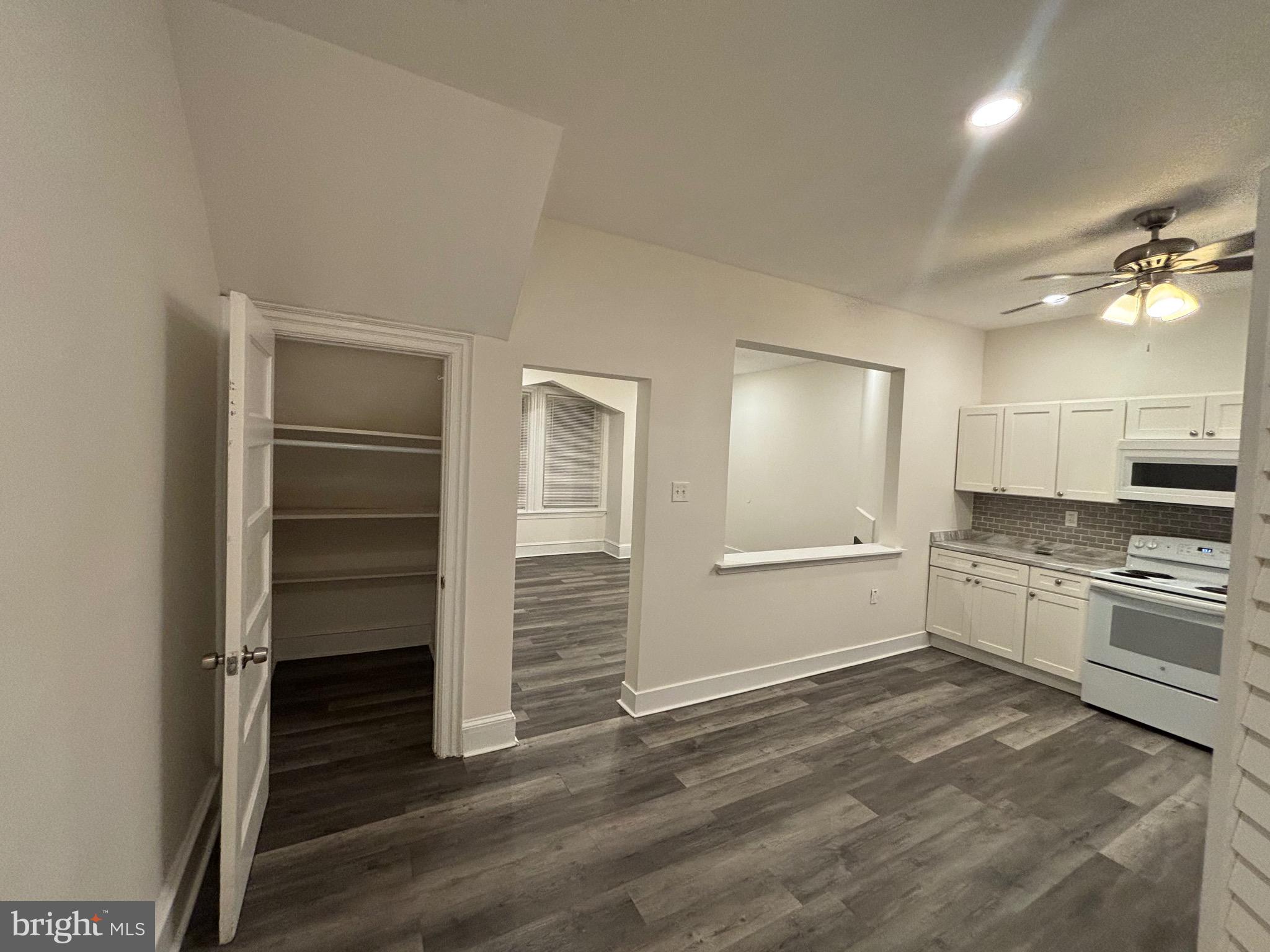 5427 Walnut Street, Unit F1 Philadelphia, PA 19139 - Photo 8 of 22 a large white kitchen with a stove a sink and dishwasher