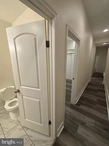 a view of a hallway with wooden floor and glass door
