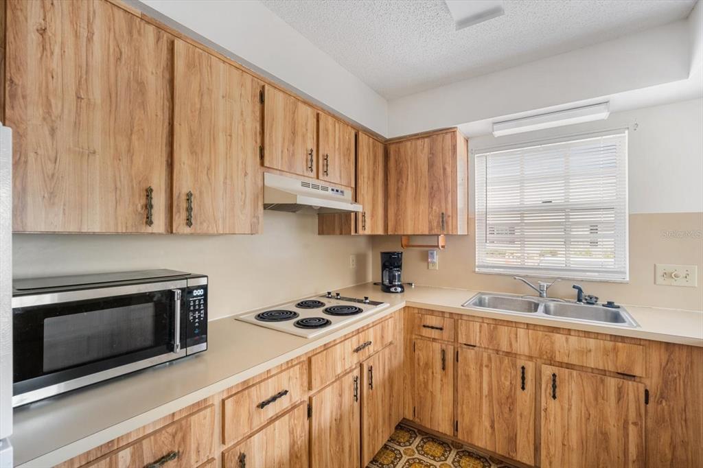 6636 Timbercove Lane New Port Richey, FL 34653 - Photo 7 of 20 a kitchen with stainless steel appliances a stove a sink a microwave and cabinets