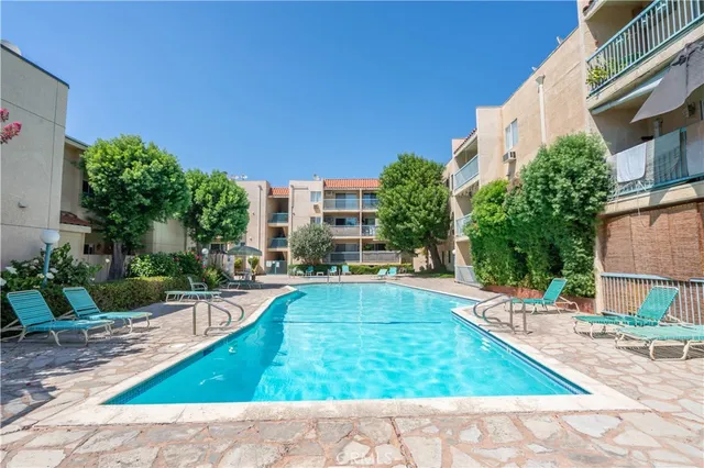 a view of a backyard with plants and swimming pool