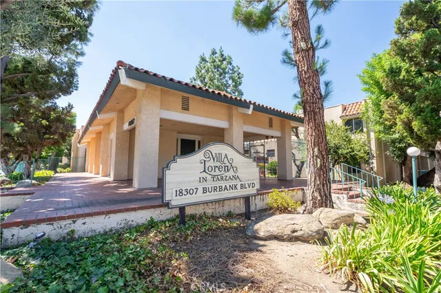 a view of a house with a bench next to a yard