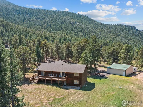 an aerial view of a house with swimming pool and mountain view