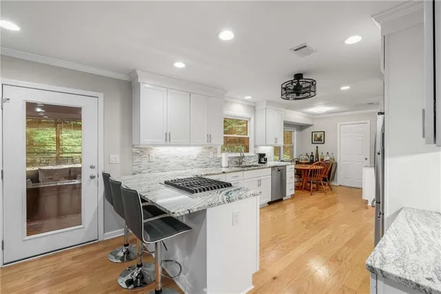 a kitchen with a stove a refrigerator and wooden floor