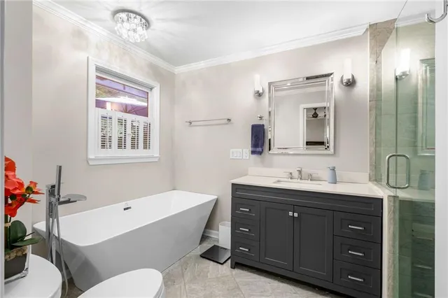 a bathroom with a granite countertop sink mirror bathtub and toilet